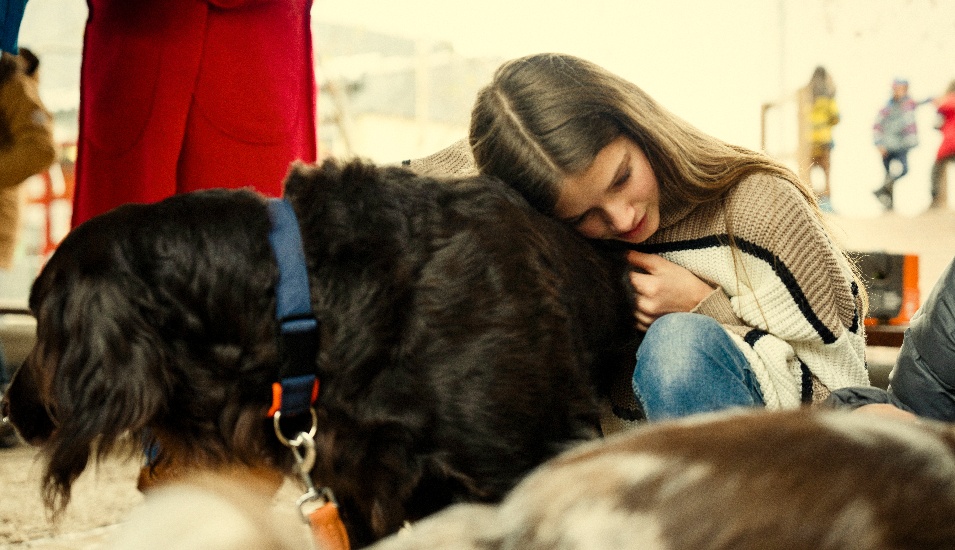 Mädchen kuschelt mit Hund