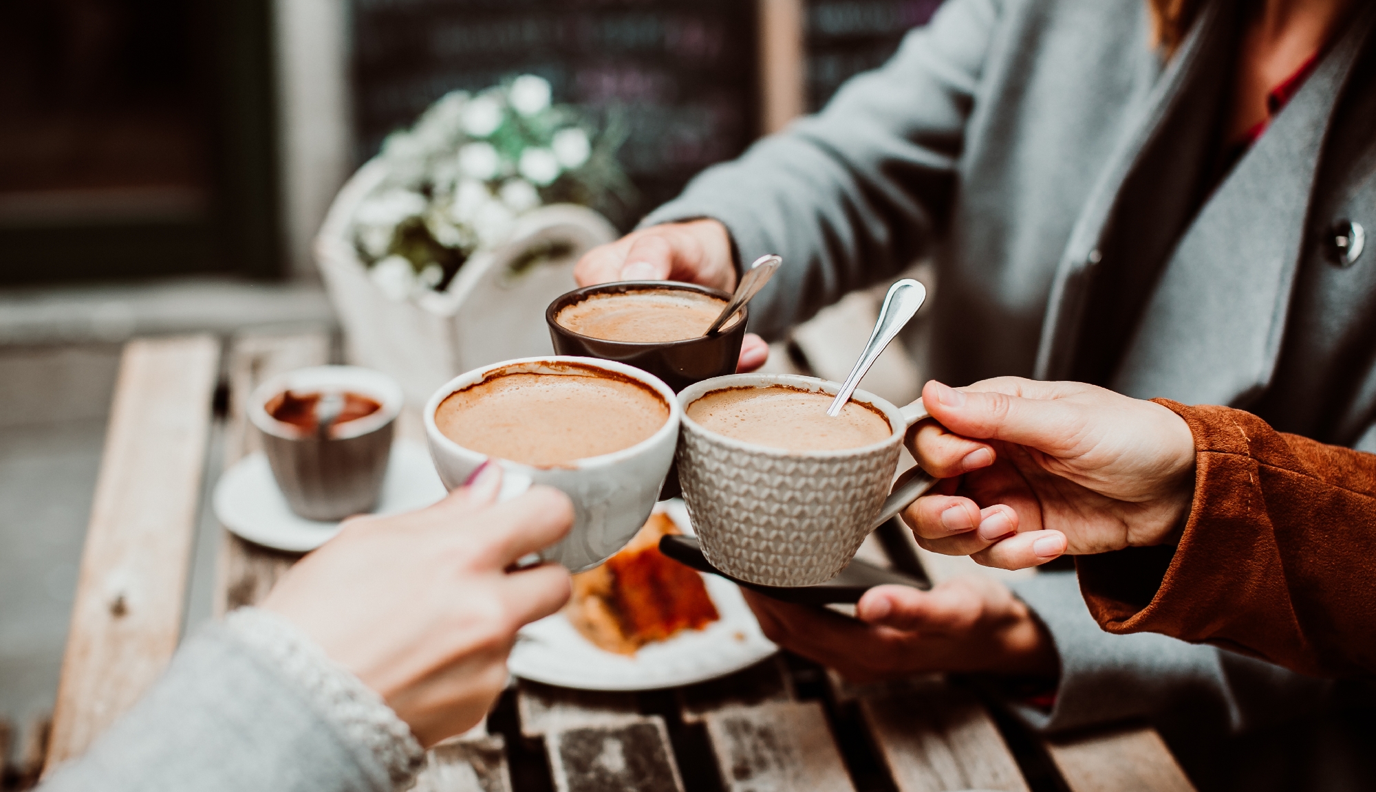 Den Traum vom Frieden träumen viele Menschen zu Weihnachten Foto dreier Menschen, die mit vollen Tassen anstoßen