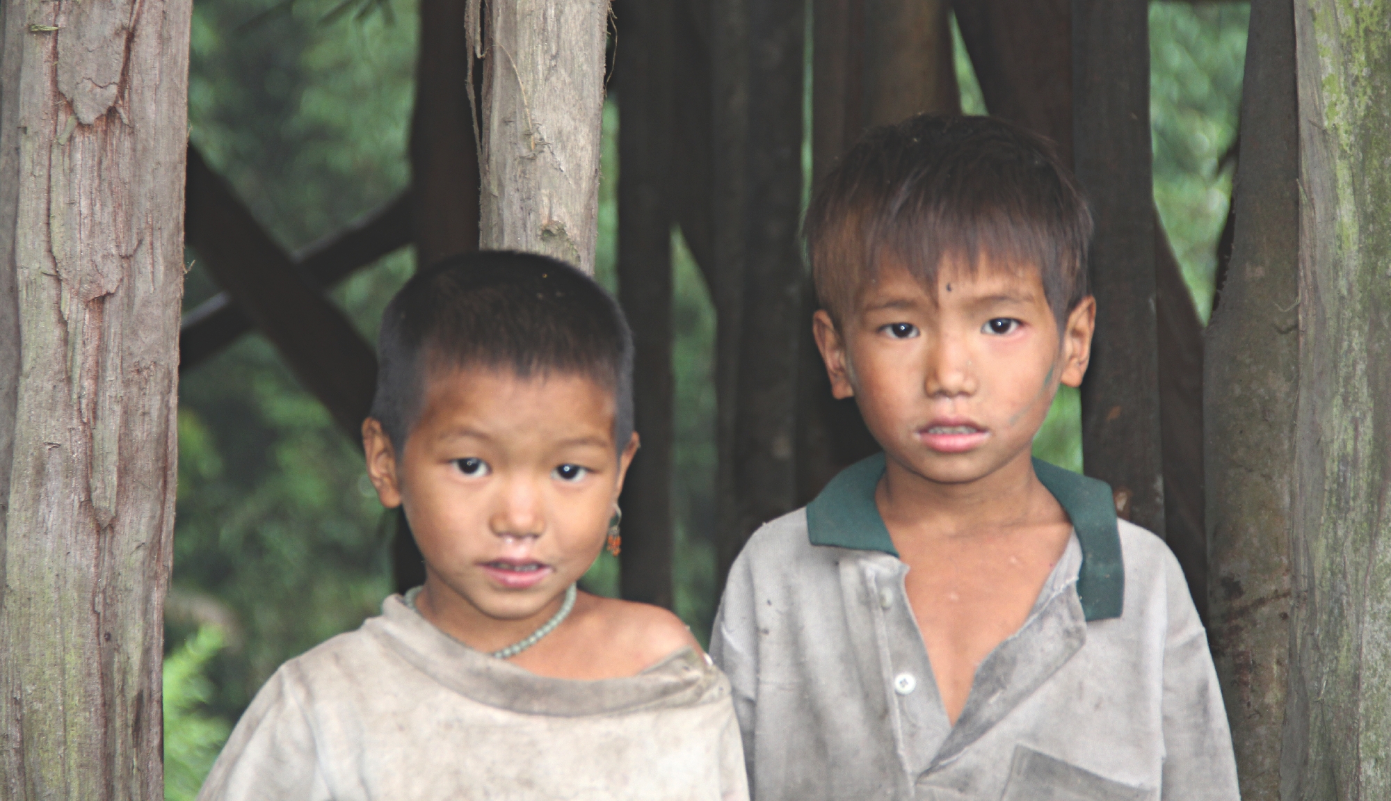 2 Kinder vor einem einfachen Unterstand aus Holz