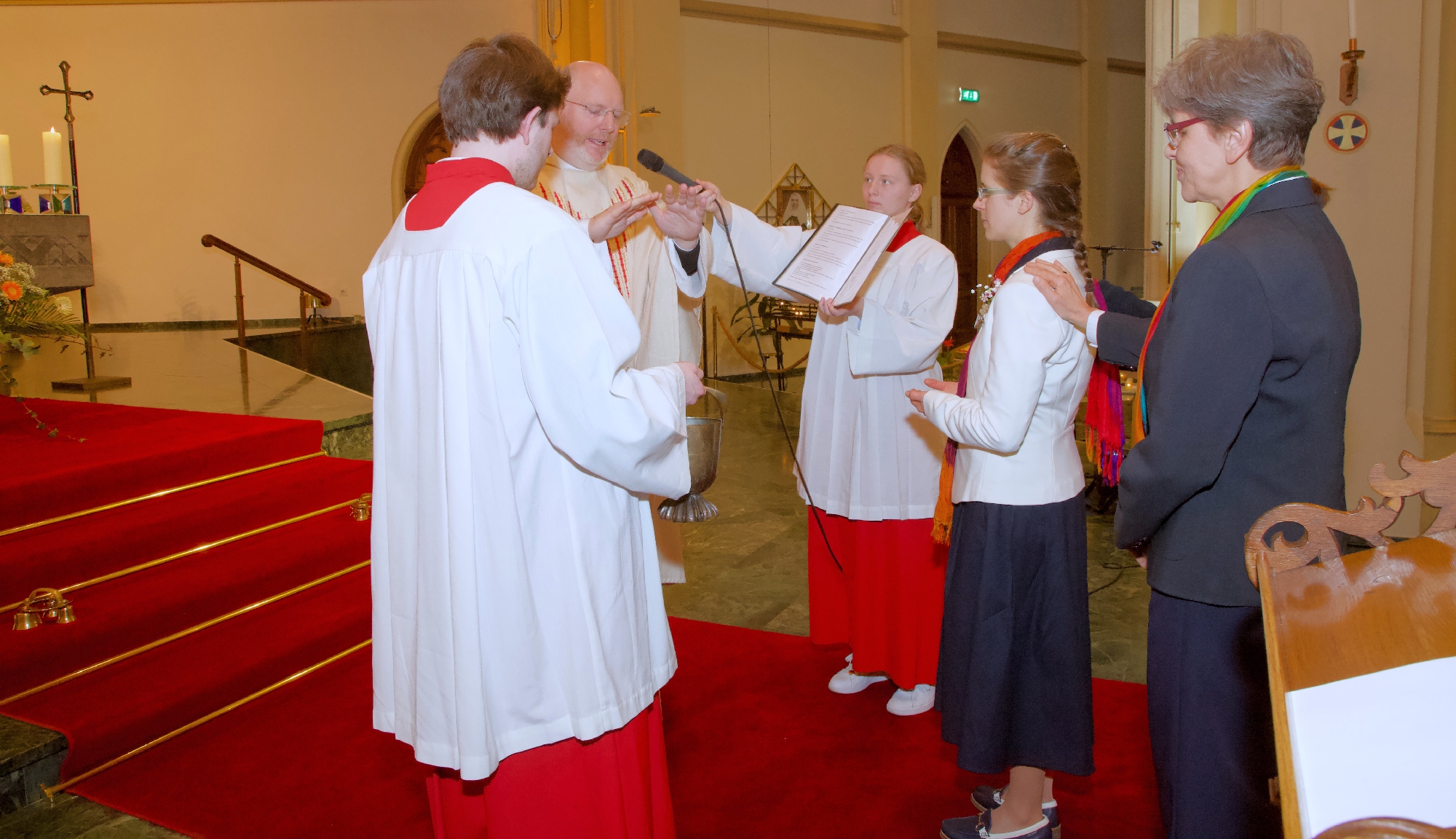 Den Rücken gestärkt Mehrere Ordensschwestern und ein Priester stehen im Altarraum um Sr. Anne-Sophie; einige haben ihr die Hände aufgelegt