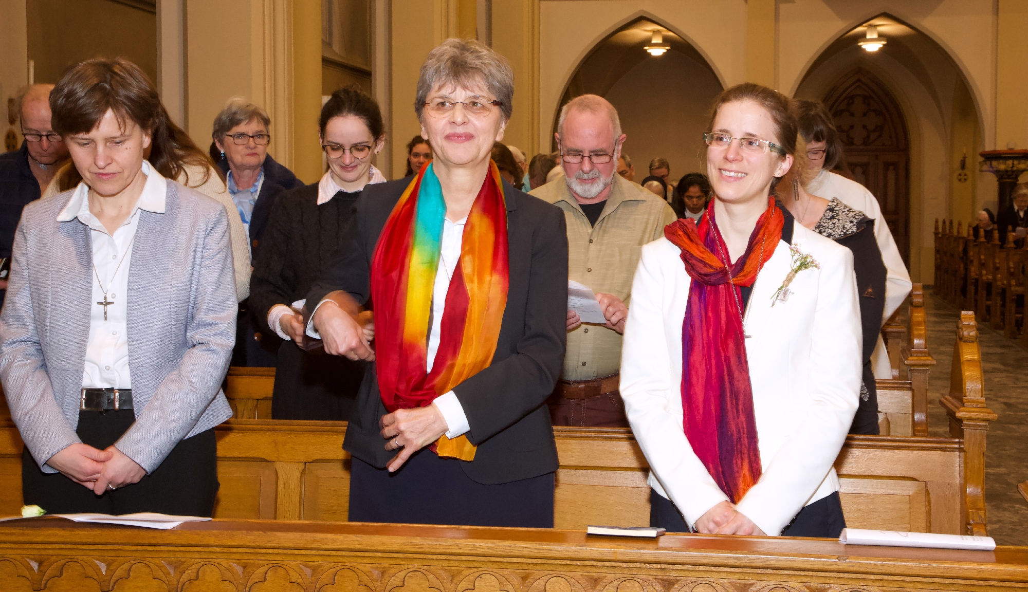 Getragen von Gemeinschaft Gruppe von Ordensschwestern und weiteren Mitfeiernden steht während eines Gottesdienstes in einer Kirche zusammen