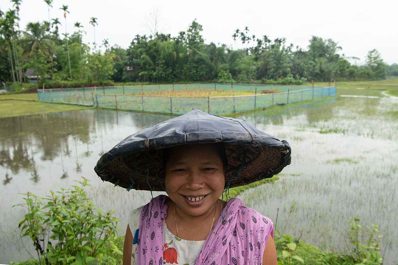Stolz steht Anima Rani Debbarma, 44, vor ihrem nassen Feld. Früher wuchs dort nur Reis. Seit sie beim Projekt der Steyler mitmacht, erntet sie auch Kartoffeln, Mais, Auberginen, Chili- und Okrapflanzen.