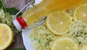 Flasche mit Zitronen und Holunderblüten