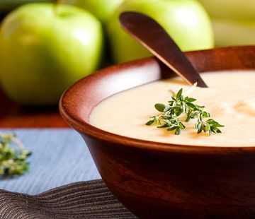 Suppenschale mit Äpfeln im Hintergrund