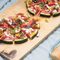 Melonenspalten belegt mit Radieschen, Tomaten, Pfirsich und Feta