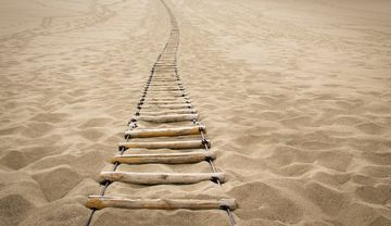 Foto einer Strickleiter im Sand