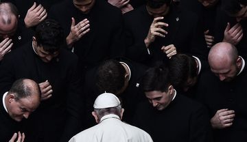 Papst Franziskus umringt von Priestern