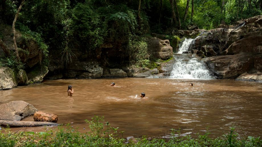 Guaraní-Kinder spielen im Wasser eines Teichs in Argentinien