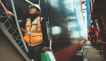 Pater Ritchie SVD betritt ein Schiff am Hamburger Hafen