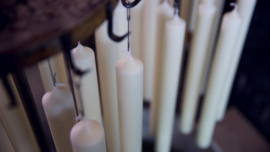 Kerzen hängen zum Trocknen an einem Gestell