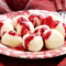 Teller voller Topfenknödel mit roter Sauce