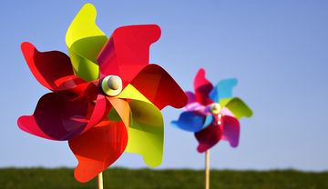 Zwei bunte Windräder auf einer Wiese
