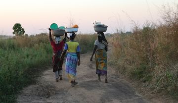 Drei Frauen, die Einkäufe auf ihren Köpfen transportieren