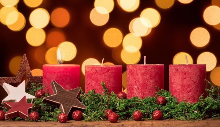 Adventskranz mit einer brennenden Kerze