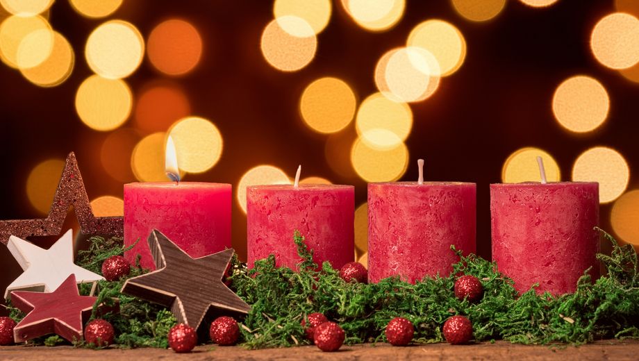 Adventskranz mit einer brennenden Kerze