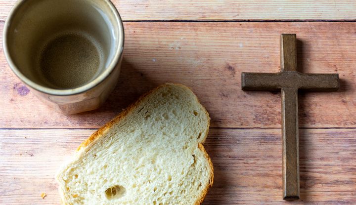 Ein Becher, dazu ein St&uuml;ck Brot und ein Kreuz