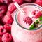 Ein Glas Himbeercreme vor zahlreichen Himbeeren