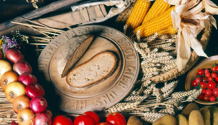 Ein gedeckter Tisch mit Brot, &Auml;pfeln und &Auml;hren