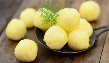 Kartoffelnknödel in einer Pfanne und ein Zweig Dill