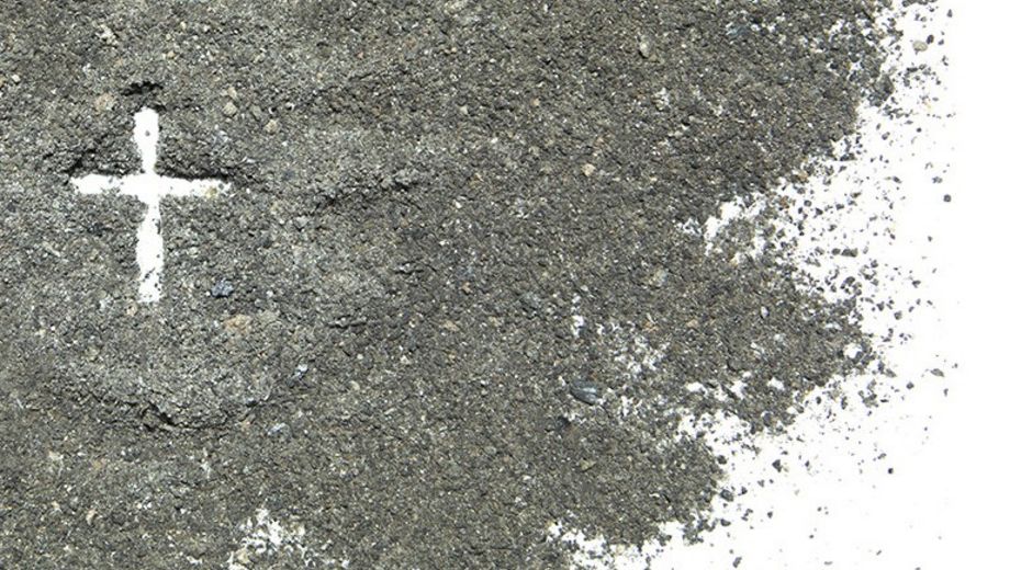 Ein weißes Kreuz in Asche gezeichnet