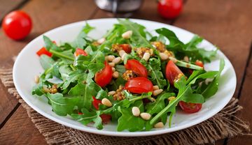 Ein Teller Brotsalat mit Rucola und Tomate